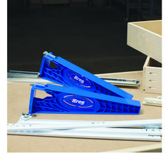 three pieces of blue plastic sitting on top of a wooden table next to some drawers