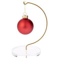 a red christmas ornament hanging from a gold - plated metal stand on a white background