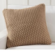 a crocheted pillow sitting on top of a white couch