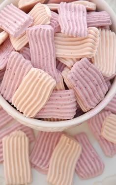 a bowl filled with pink and white striped cookies