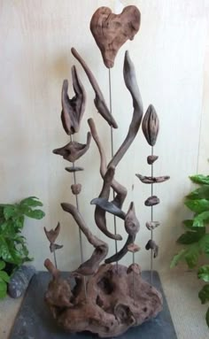 a sculpture made out of driftwood with flowers and hearts on it's sides