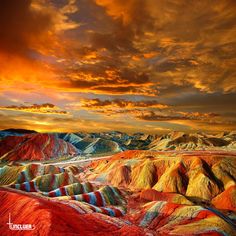 the colorful hills are painted with different colors and shapes, as well as clouds in the sky