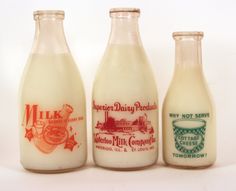 three old milk bottles sitting next to each other