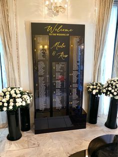 a black and white display case with flowers in vases on the floor next to it