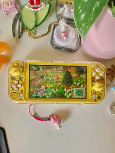 an image of a game on a cell phone next to other toys and accessories that are sitting on a table