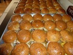 rolls are lined up on trays in a bakery