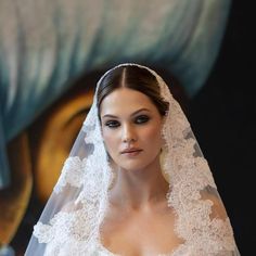 a woman in a wedding dress with a veil on her head and an eyeliner