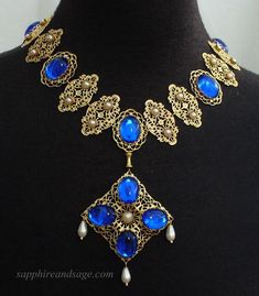 Wear a piece of history with this "Mary, Queen of Scots" movie-inspired reproduction Tudor necklace. Crafted with ornate gold-tone filigrees and captivating acrylic cabochons, this regal accessory adds unique glamor to any look. Necklace length is 17-18", with a 2-3" extender attached. Longer and shorter lengths available upon request, message me with your desired length. Baroque Necklace With Historical Design As A Gift, Baroque Historical Design Necklace For Gift, Vintage Baroque Jewelry With Historical Design, Ornate Antique Gold Jewelry With Historical Design, Costume Gold Metal Jewelry, Elegant Gold Costume Jewelry, Elegant Gold Jewelry For Costume, Ornate Jeweled Necklaces, Vintage Filigree Baroque Jewelry