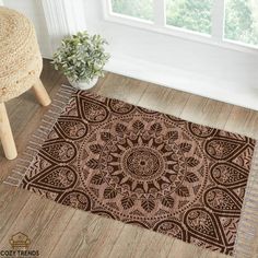 a brown and white area rug sitting on top of a wooden floor next to a window