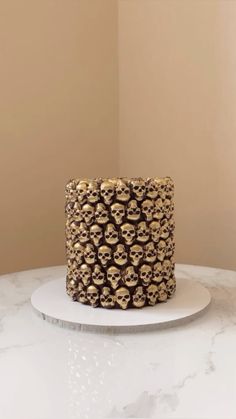 a cake decorated with gold skulls on a white plate