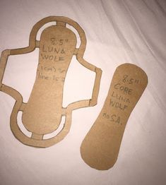 two pieces of cardboard cut out to look like shoes with words written on the soles