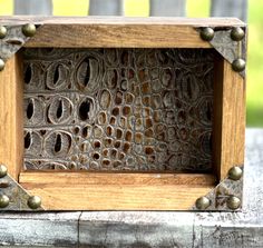 a close up of a wooden frame with metal studs on the outside and inside