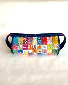 a multicolored patchwork pencil case sitting on top of a white surface