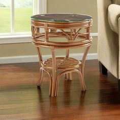 a small table with a glass top in front of a couch and window sill