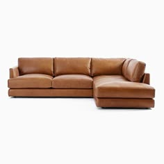 a brown leather sectional sofa sitting on top of a white floor