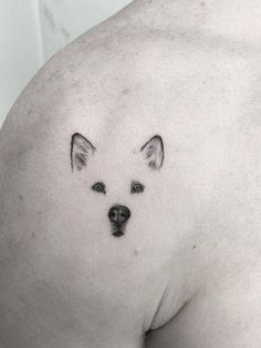 a dog tattoo on the back of a man's shoulder