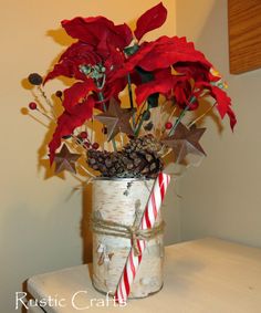 a vase filled with flowers and candy canes on top of a white table next to a wall