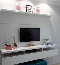 a flat screen tv mounted to the side of a white wall in a living room