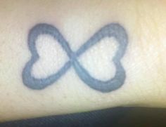 an image of a tattoo with two hearts in the middle on someone's arm