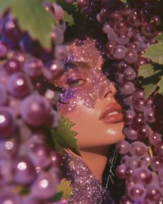 a woman's face surrounded by purple grapes