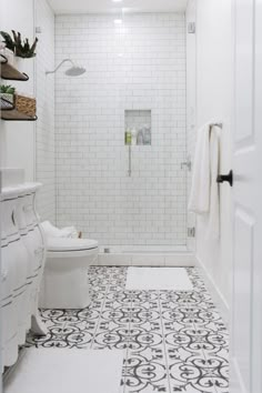 a white bathroom with black and white tile