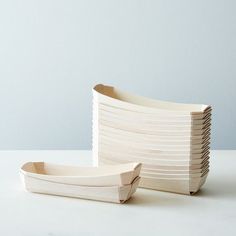 two pieces of wood sitting on top of a white table next to an empty cup