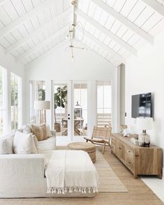 a living room filled with furniture and a flat screen tv on top of a wooden stand