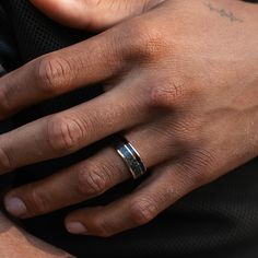 a close up of a person wearing two wedding bands on their hands and holding onto his arm