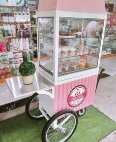 a pink and white cart sitting in front of a store