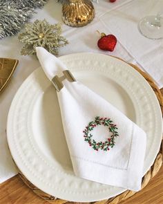 a white plate topped with a christmas wreath napkin