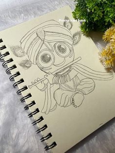 a notebook with a drawing on it next to flowers