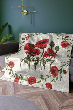 a living room with a couch covered in a red flowered blanket next to a green wall