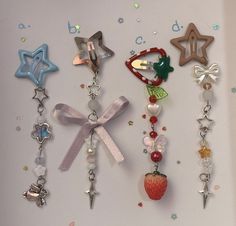 there are many charms hanging on the refrigerator door together, including strawberries and starfishs