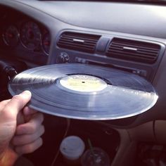 a person holding a record in their hand while sitting in the driver's seat