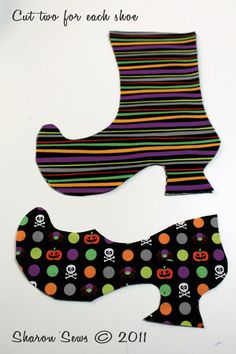 two pieces of paper cut out to look like shoes with skulls and pumpkins on them