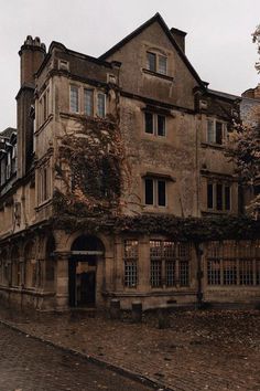 an old building with ivy growing on it's walls and windows in the fall