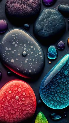 colorful rocks and water droplets on a black surface