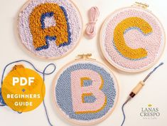 three embroidery hoops with the letters abc and c on them next to a knitting needle