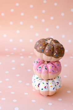 three donuts stacked on top of each other with sprinkles and chocolate frosting