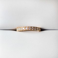 a diamond wedding band on top of a white leather seat