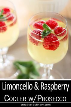 two glasses filled with lemon and raspberry cooler w / proscecco