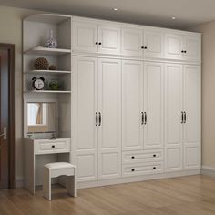 an empty room with white cupboards and shelves in the center, along with wooden floors