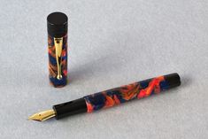 a fountain pen sitting on top of a table next to an empty ink roller bottle