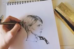 a drawing of a woman's face is being drawn on paper with pencils