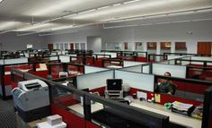 an office cubicle with lots of desks and computers