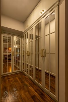 an empty room with glass doors and wood flooring is seen in this image from the hallway