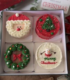 four decorated christmas cakes in a box