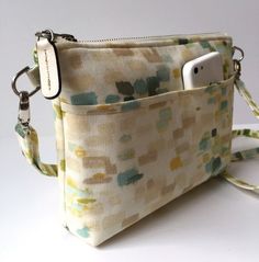 a cell phone is in the pocket of a handmade bag with an attached strap