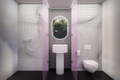 a white toilet sitting next to a sink in a bathroom under a window covered in netting