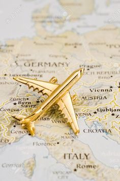 a gold airplane pin sitting on top of a map stock photo - 957982